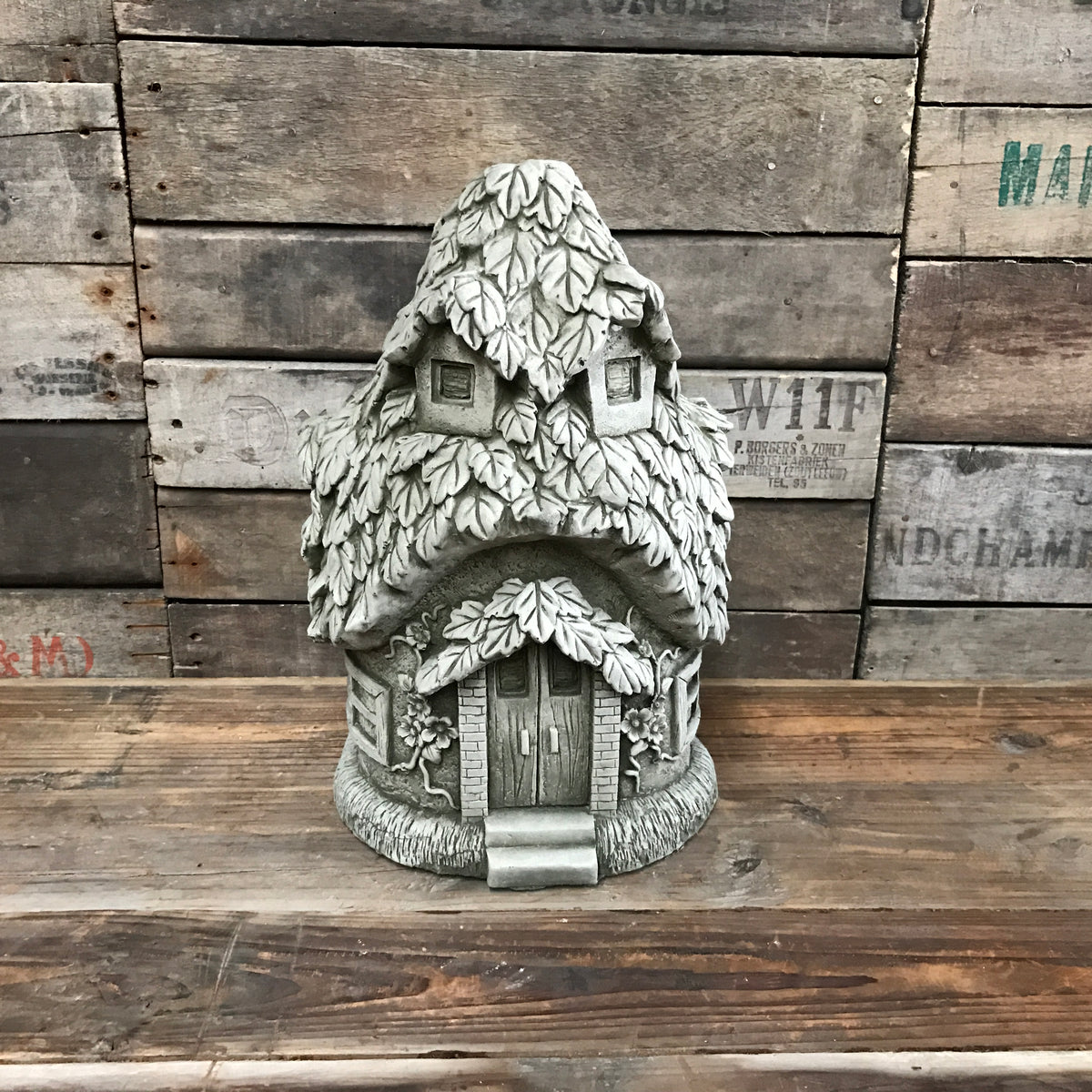 leaf-shaped metal garden ornament painted green on grass, decorative outdoor feature